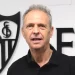 Joaquín Caparrós con el escudo del Sevilla detrás de él. | Imagen: Página web Sevilla FC.