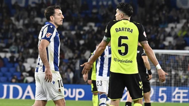 Oyarzabal dialogando con Marc Bartra durante un Real Sociedad-Betis. | Imagen: perfil de X @ZonaMixta__.