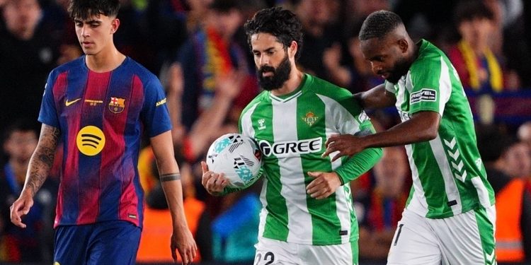 Isco siendo abrazado por Bakambu tras anotar un penalti en el FC Barcelona-Betis. | Imagen: perfil de X @RealBetis.